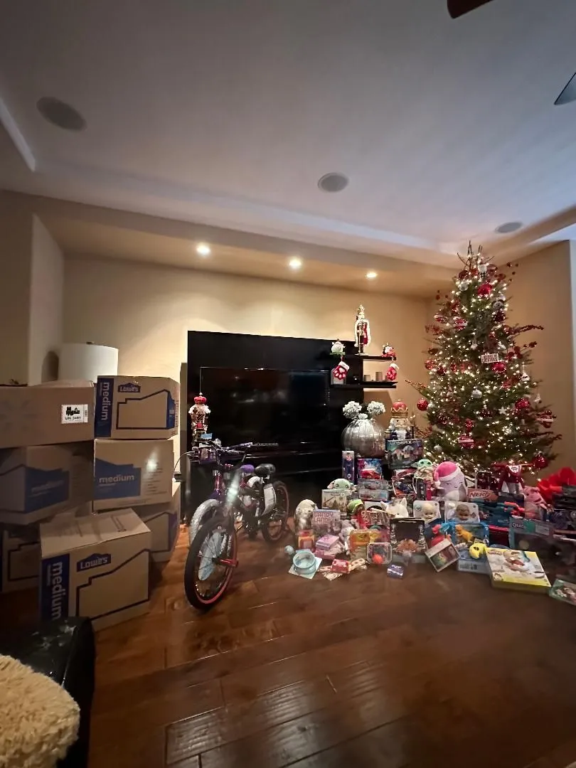 Donated toys gathered beside a Christmas tree