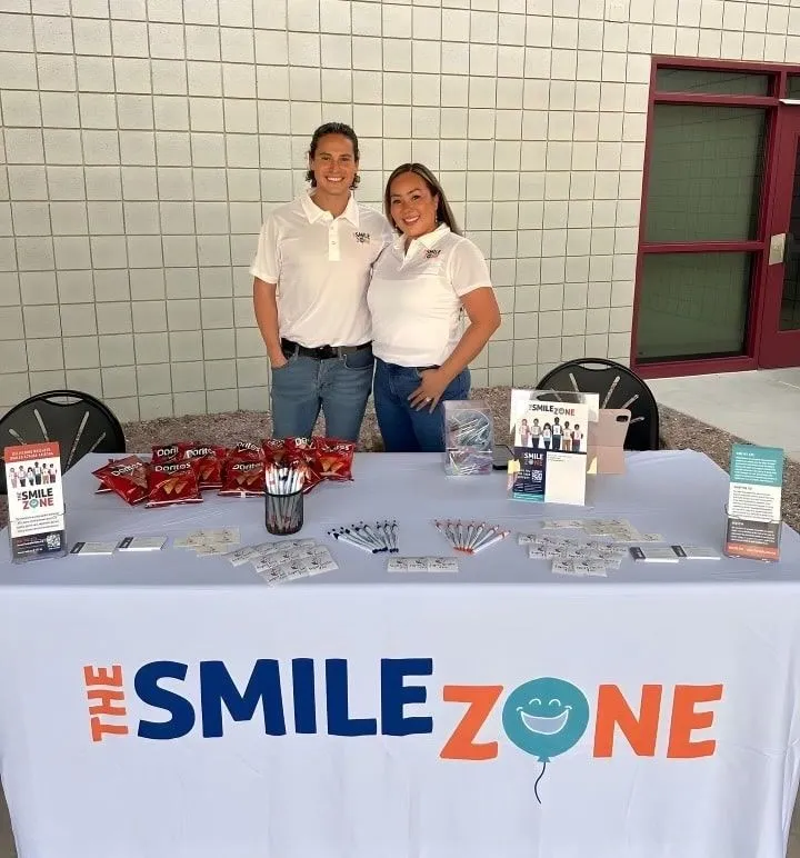 Two TheSmileZone team members at their outreach table