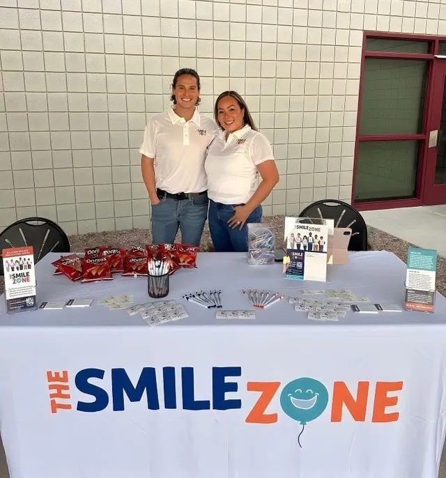 Two TheSmileZone team members at their outreach table